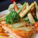 A beautifully plated salmon dish with fresh vegetables and lemon slices, perfect for a gourmet meal.